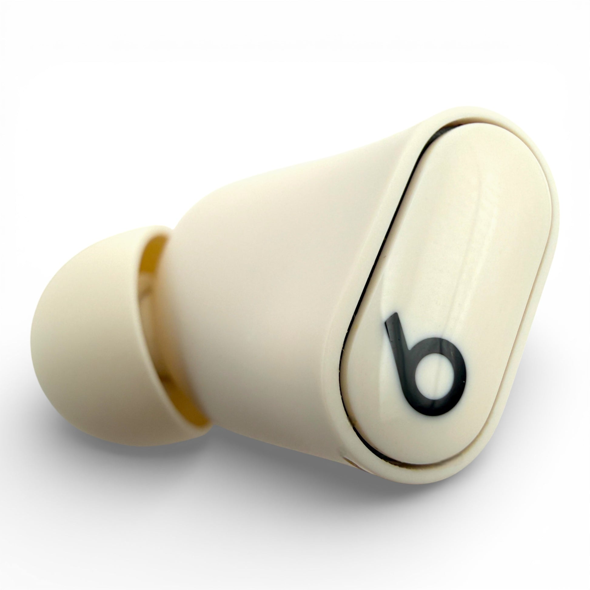 Left Beats Studio Buds+ earbud in ivory, top view showing the logo and ear tip
