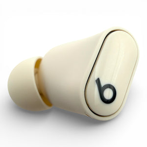 Left Beats Studio Buds+ earbud in ivory, top view showing the logo and ear tip