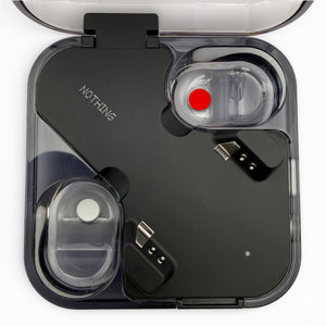 Nothing ear charging case in black, open view showing both earbuds seated inside with charging pins visible