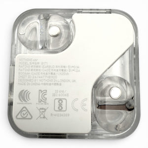 Nothing ear charging case in white, underside view showing the earbuds and product information label