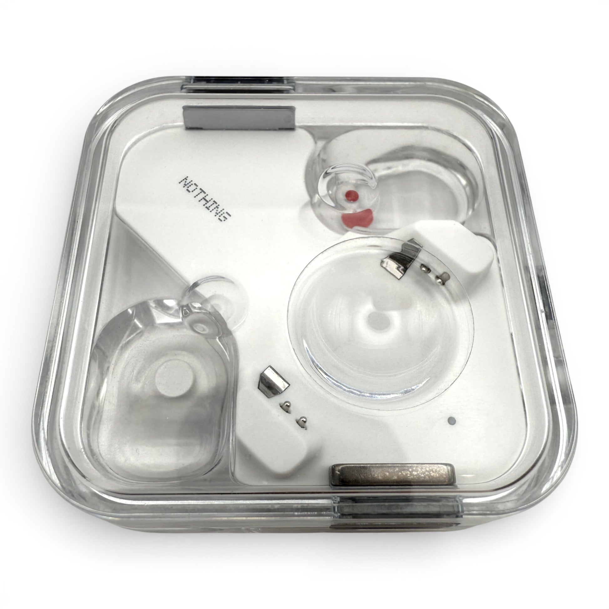 Nothing ear charging case in white, closed lid view with the earbuds visible through the transparent top