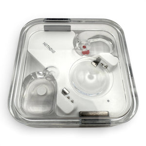 Nothing ear charging case in white, closed lid view with the earbuds visible through the transparent top
