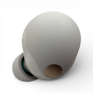 Left replacement Sony WF-1000XM5 earbud in white, top view showing the speaker mesh and ear tip attached